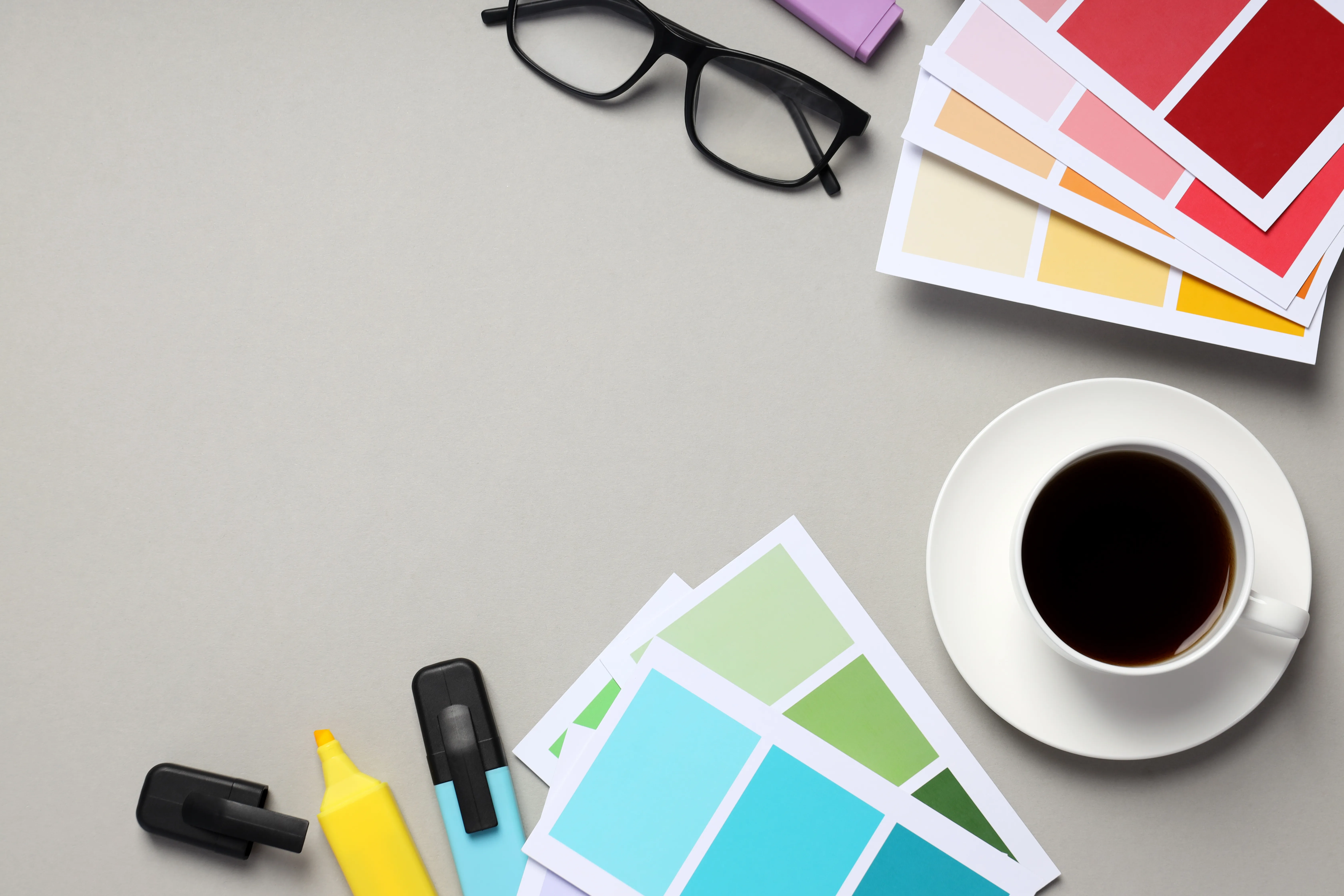 A design desk with colour palettes, markers, and coffee